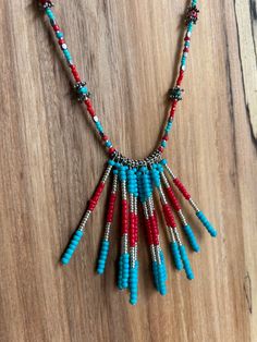 Turquoise and coral colored, beaded, turquoise choker Turquoise Beaded Dangle Necklaces, Turquoise Multi-strand Jewelry With Tiny Beads, Unique Turquoise Jewelry With Tiny Beads, Multi-strand Beaded Turquoise Jewelry, Adjustable Multi-strand Turquoise Necklace With Colorful Beads, Turquoise Beaded Necklaces With Spacer Beads, Turquoise Beaded Necklace With Spacer Beads, Turquoise Beaded Choker With Round Beads, Bohemian Turquoise Necklace With Spacer Beads