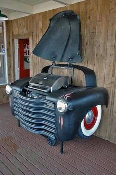 an old fashioned car is on display at the museum's front porch, with it's hood up