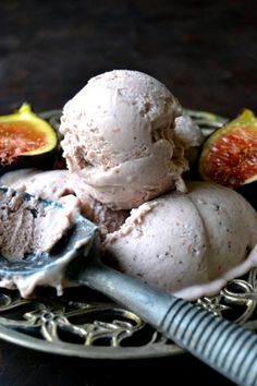 three scoops of ice cream on a plate with figs