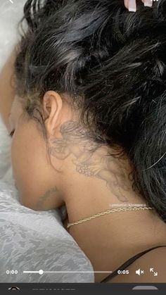 the back of a woman's head with tattoos on it