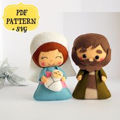 two little dolls are dressed up as jesus and mary, one is holding a baby