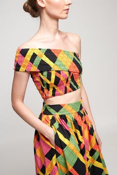 a woman in a multicolored top and skirt