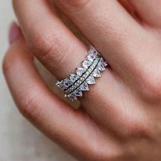 a woman's hand with a ring on top of her finger and an open diamond band