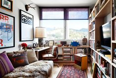 a living room filled with lots of furniture and bookshelves next to a window