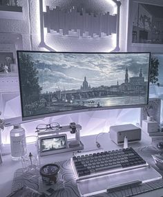 a computer monitor sitting on top of a desk next to a keyboard, mouse and glasses