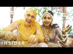 two people covered in yellow paint sitting next to each other with their hands on the ground