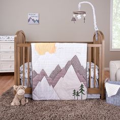 a baby crib with mountains and trees on it