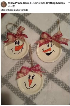 three snowman ornaments hanging from strings on top of a table with plaid fabric and red bows