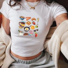 We love this fun, colorful Girl Breakfast Collage Baby Tee! This adult sized tee is soft and super comfy and is made of 52% cotton and 48% polyester for a luxurious lightweight stretch. The designs are printed with DTF which delivers a vivid, detailed design with a textured feel. This tee is a perfect blend of coquette fashion and nostalgic Y2K vibes, making it a trendy addition to your casual wardrobe. Made with soft, comfortable material, it's ideal for everyday wear or for making a statement White Y2k Cropped T-shirt, Trendy Cropped T-shirt With Funny Print And Short Sleeves, Trendy Cropped T-shirt With Funny Print, Casual White Cropped T-shirt With Funny Print, Cute Cropped Cotton T-shirt, Funny Print Graphic Tee Cropped T-shirt, Multicolor Cartoon Print Y2k Tops, Y2k Spring T-shirt With Cartoon Print, Cute Summer Crop Top With Funny Print