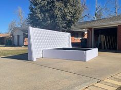 a mattress sitting in the middle of a driveway