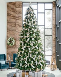 a decorated christmas tree in the middle of a living room with presents on the floor