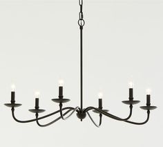 a black chandelier with six lit candles hanging from it's center point