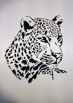 a cutout of a cheetah's head on a white background with black dots