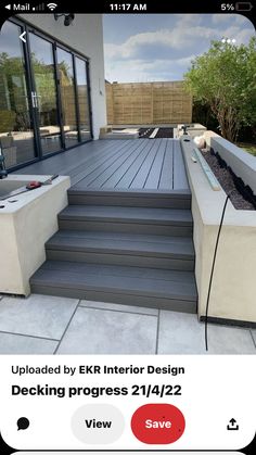 an outdoor deck with steps and planters in the middle, surrounded by landscaping materials