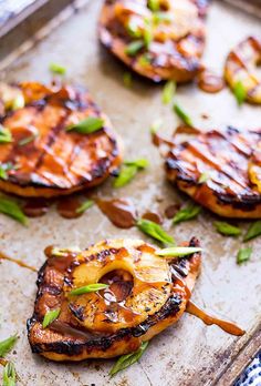 grilled pineapple burgers on a baking sheet with green onions and mint garnish