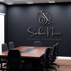 an empty conference room with black chairs and a wooden table in front of the wall