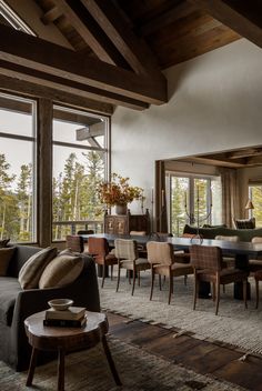 a living room filled with lots of furniture and large windows next to a wooden floor