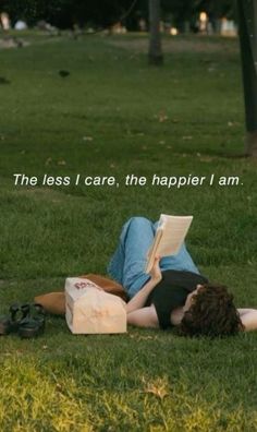 a person laying on the grass reading a book