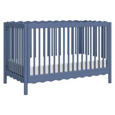 a blue crib with white sheets on the bottom and bottom part, in front of a