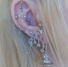 a close up of a person's ear with different types of piercings on it