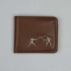 "Unique embroidery made by Georgian famous artist Tutu Kiladze. Handmade in Georgia, Genuine leather wallet. * Genuine leather * No lining * Lightweight  * Waterproof * Embroidery \"Fencing\" Dimensions: 11 x 9 (4,3 x 3,5 inches)                        11 x 10 (4,3 x 3,9 inches) DELIVERY INFO If you have any problems with your order, do not hesitate to contact us. We always try to get orders out as quickly as possible. Remember, that we don't own delivery services and can't control this process. So, if you have trouble with the time of shipping - check if your product was sent correctly. If all were sent in time - the problem is from the part of the delivery service. If you are ordering for a gift, just let us know and we would be happy to include a personalized note from you. Check out ou Brown Leather Wallet With Leather Patch, Classic Bifold Wallet With Leather Patch, Vintage Brown Wallet With Leather Lining, Bifold Wallet Pattern, Hand-stitched Leather Trifold Wallet, Hand-stitched Brown Leather Wallet, Slim Leather Wallet, Brown Leather Wallet, Custom Wallet