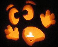 carved pumpkin faces with a lit candle in the middle