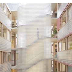 a tall white building with lots of windows next to a stair case in front of it