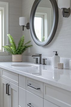 a bathroom with two sinks and a large round mirror on the wall above it's counter