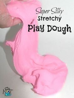 a hand holding a pink play dough with the words super silly stretchy play dough on it