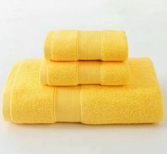 three yellow towels stacked on top of each other in front of a white background,