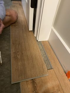 a man laying on the floor next to a door with a ruler in front of it