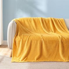 a couch with a yellow blanket on it