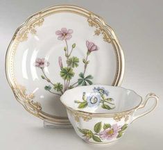 two porcelain dishes with flowers painted on them, one is white and the other has gold trim