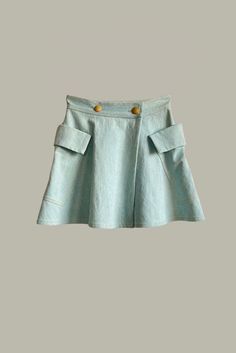 Fabric & Color: 12oz. Washed indigo Denim in Oxide Blue Details: Double breasted button front closure Side overlayed pouch pockets Clean finished French seams Light maize colored stitching Vintage deadstock buttons made in Italy Can be worn as a cape as well Handmade Locally Denim Blue Cotton Skirt With Belt Loops, Fitted Cotton Skirt With Buttoned Pockets, Blue Denim Skirt With Side Pockets For Spring, Blue Cotton Denim Skirt With Patch Pockets, Fitted Washed Blue Denim Skirt With Pockets, Cotton Denim Skirt With Buttons For Work, Spring Blue Denim Skirt With Patch Pockets, Blue Denim Skirt With Patch Pockets For Spring, Blue Bottoms With Buttoned Pockets For Work