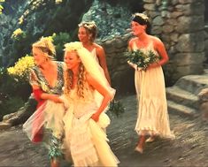 three women in wedding dresses are walking down the street