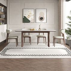 a dining room with white walls and wooden flooring, two paintings on the wall