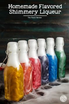 six bottles filled with different colored liquid sitting on top of a white cloth covered table