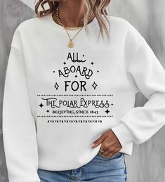 a woman wearing a white sweatshirt that says, all aboard for the polar express