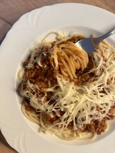 a white plate topped with spaghetti and meat