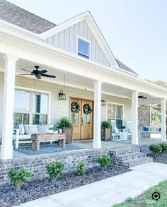 the front porch of a white house with blue accents