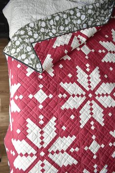 a red and white quilted bed with two pillows