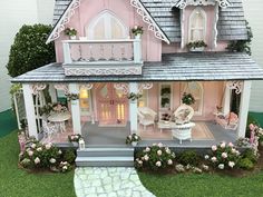 a doll house with furniture and flowers on the lawn