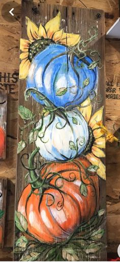 some pumpkins and sunflowers painted on wood