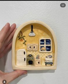 a hand is holding a ceramic dish with various items on it