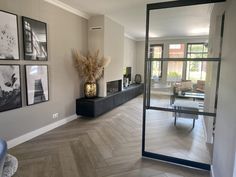 a living room filled with furniture and pictures hanging on the wall above it's glass doors