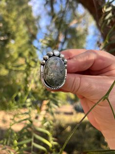 This moss agate gemstone inspired the Everglades Ring design.  The agate features green plumes that create depth and dimension at every angle. The ring also features a mother of pearl and 6 hand formed silver ball elements.  The ring features a straight ring shank in a size 8.  The ring will be packaged in a black gift box perfect for storing or gifting! Bohemian Moss Agate Gemstone Jewelry, Bohemian Silver Jasper Jewelry, Bohemian Agate Ring With Large Stone, Silver Ocean Jasper Bohemian Jewelry, Silver Bohemian Ocean Jasper Jewelry, Distinctive Green Jasper Jewelry, Unique One-of-a-kind Ocean Jasper Jewelry, Handmade Oval Moss Agate Ring, Handmade Silver Rings With Moss Agate