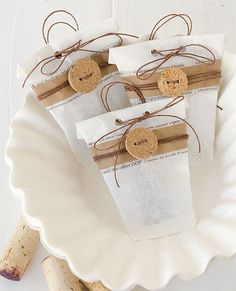 three wine corks are wrapped in brown paper and tied with twine on a white plate