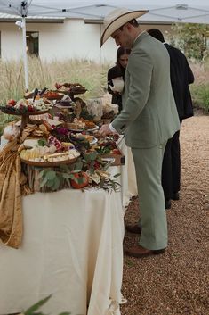 a man standing next to a table covered in food