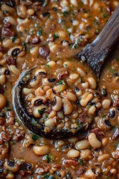 the beans are cooked and ready to be eaten in the skillet with a wooden spoon