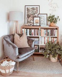 a living room filled with furniture and bookshelves next to a lamp on a table